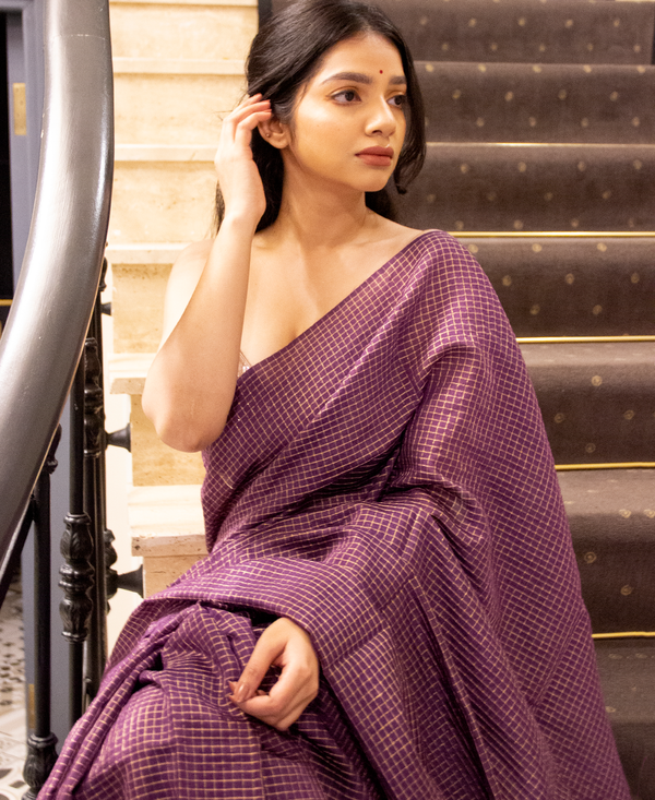 An Indian woman in a purple check silk saree